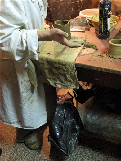 The bags of clay are smiling while pottery teacher explains the technique 