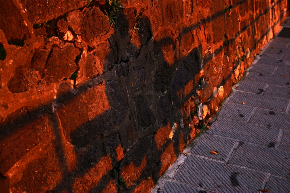 An elderly couple sit arm in arm to watch the sun set. Levanto, Italy