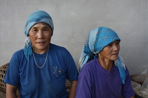 Two Akha women take a moment to rest between their six-hour days in the coffee fields and their numerous domestic responsibilities. Females play a large role in Akha society and culture.  