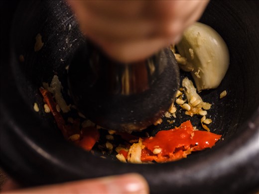 Crushing the ingredients with a mortal and pestle