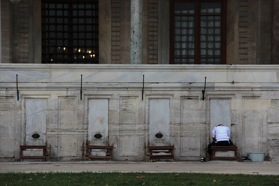 This boy was lost in thought as he  was washing his feet before prayer. 