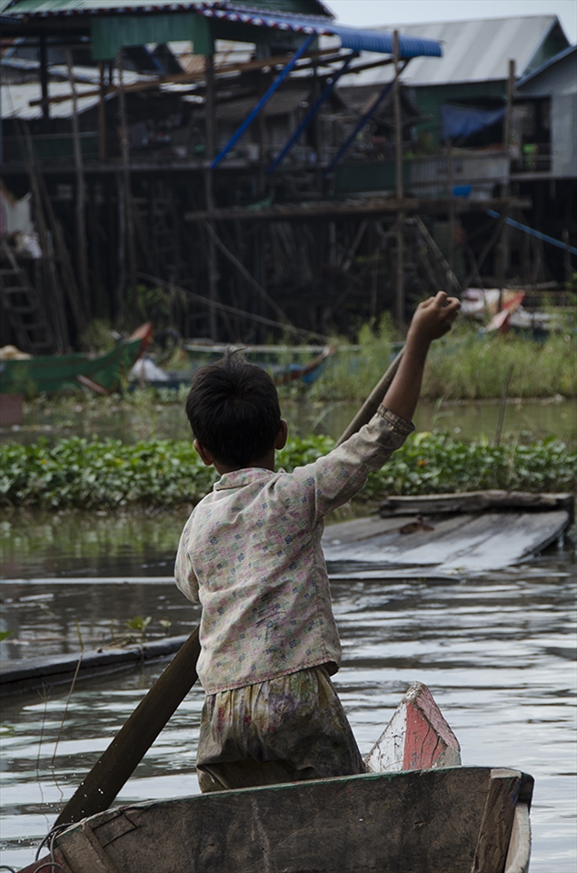 Even young children learn how to navigate with a boat in Kompong Phluk.