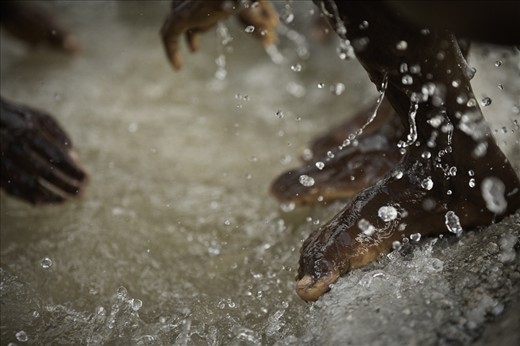Street children discovered a puddle of water leaked from a freshly dug well. 