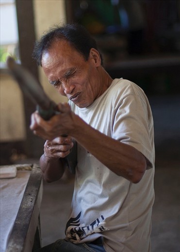 Most lepers in town still feel ashamed about their illness, this man seems to have accepted his situation, as he asks me to take a photograph with his wooden rifle. 