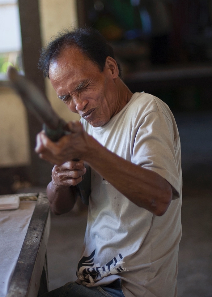 Most lepers in town still feel ashamed about their illness, this man seems to have accepted his situation, as he asks me to take a photograph with his wooden rifle. 