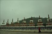 A monk walks by a monastery's mountain-side pillars in Qing Hai.: by spillthebeins, Views[377]