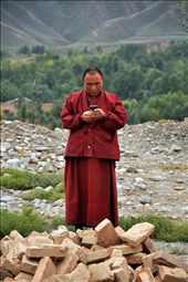 A monk texts on his cell phone on the grounds of a monastery.: by spillthebeins, Views[349]