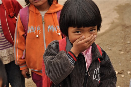 A Uyghur schoolgirl stifles a giggle on her way home from school.