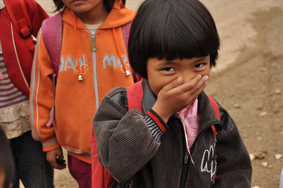 A Uyghur schoolgirl stifles a giggle on her way home from school.