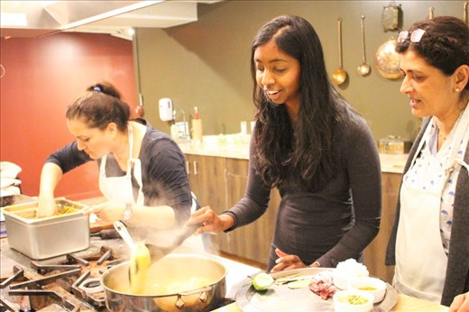 Three cooks in kitchen (two spectators)
