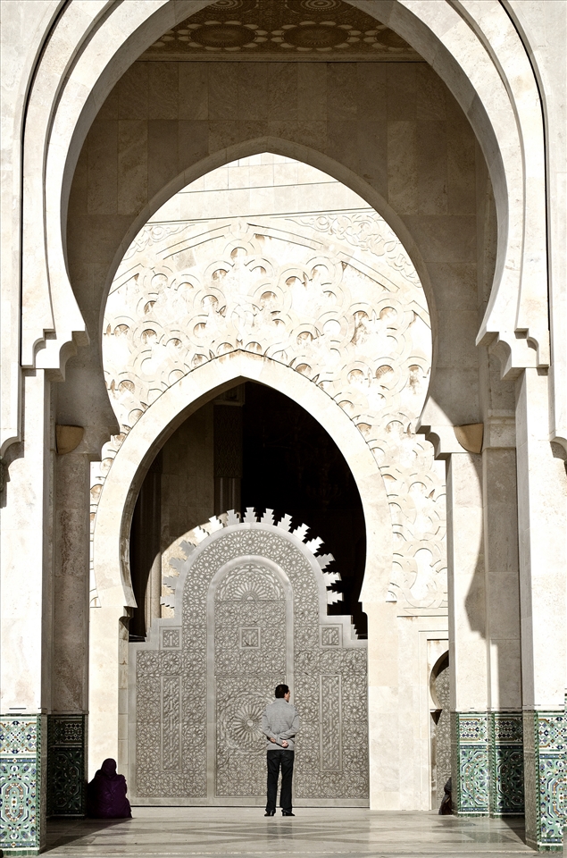A man during a moment of reflection at the Hassan II Mosque in Casablanca