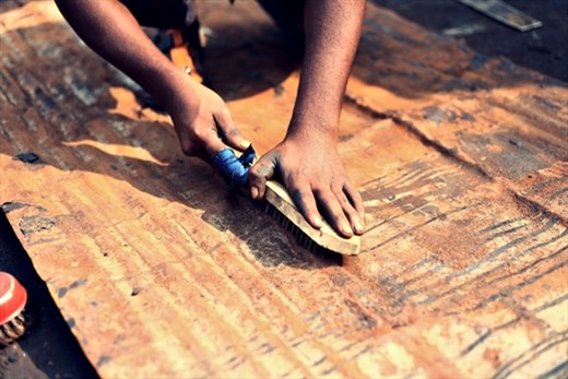 Even with wounds the workers in Dholaikhal sincerely cleans the old metal
