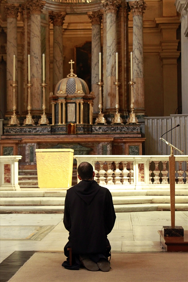 Praying..In a small church a man on his knees prays for forgiveness.