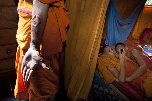 A monk show his new sank yant tatto while the other play with their phone. Modern era also touch this simple community. In their free time, they will play with cell phone their bring from their home town. Usually they kill some time with reading book, play with others monk or just sit and watching the Wat