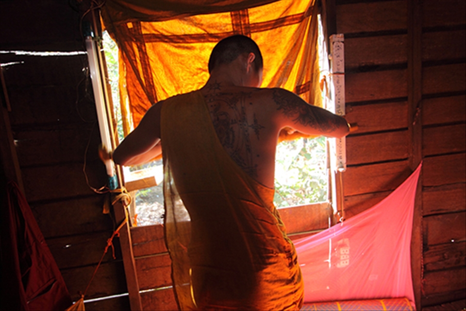 A monk cover the window from  sun. The monks spent a whole day in shrine. Learn about simplicity life, history of the Wat and playing with classmate.