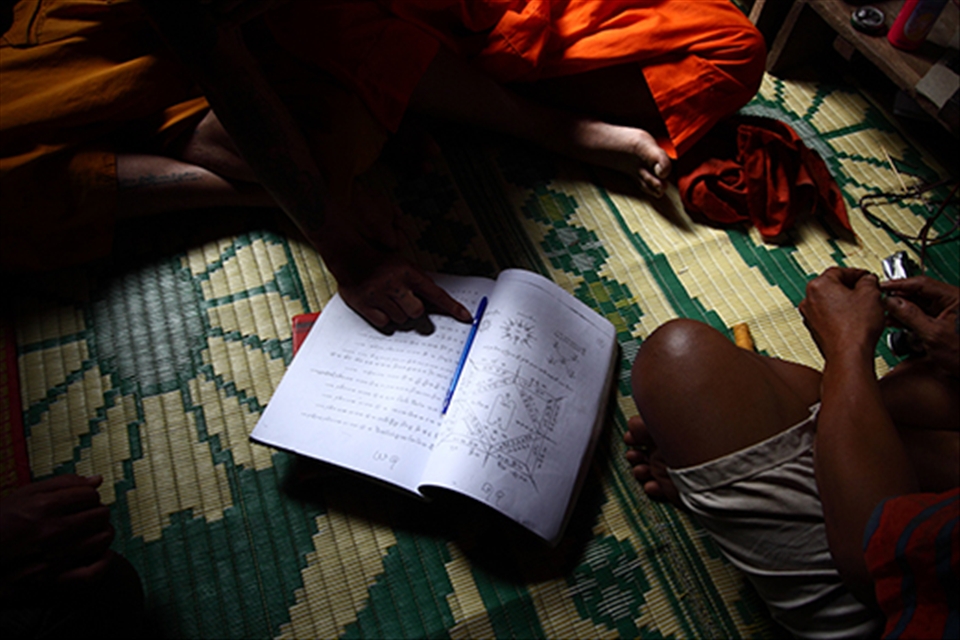 A young monk chose his sank yant tatto design. Many design provide by tatto artist to chosen by monk. The artist do it for free, he just want the bless from the monk