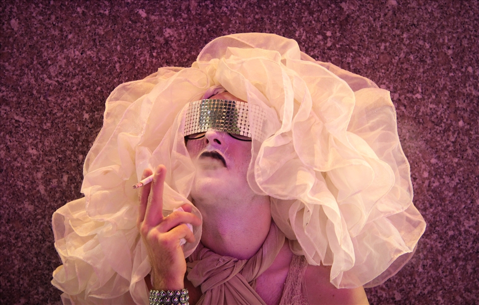 It was a late night in the city and it was Fashion’s Night Out, I was walking around with my wife and we turned a corner and had to wait for a walk light to turn green. My wife turned around and saw this person sitting there enjoying a smoke. She turned to me and said, “Quick, take a photo!” so I turn around and ask, what turned out to be, this man if he’d pose for a photo for me. He was more than happy to oblige and I was able to get this shot.