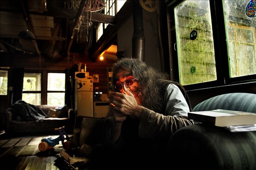 A man lights up in a forest cabin