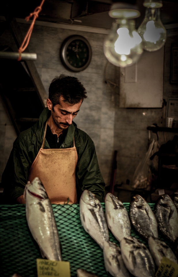 This is a photo that I took during one of my travels in Istanbul, Turkey. The man starts to clean the fishes to the costumers starting from early morning till late evening, and this hard life reflected on his attitude in a serious way.