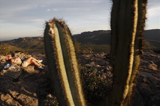 A tourist relaxes at sunset on top a mountain in Chapada Diamantina.