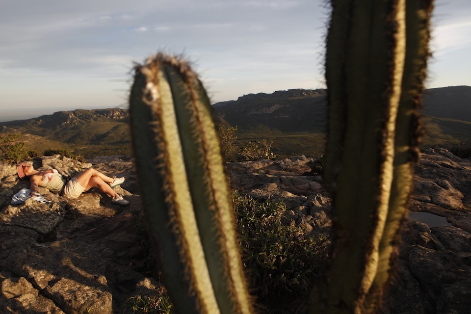 A tourist relaxes at sunset on top a mountain in Chapada Diamantina.