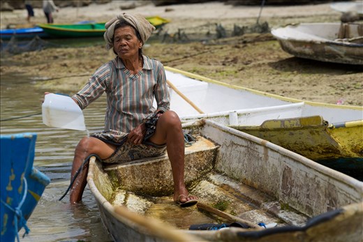 An older woman bails the water from her boat before going back out to harvest. There are almost no young people working in the seaweed farms anymore. They prefer to try to make easier money from the tourists. We watched many young men sit and watch as small elderly women struggle with heavy work. 