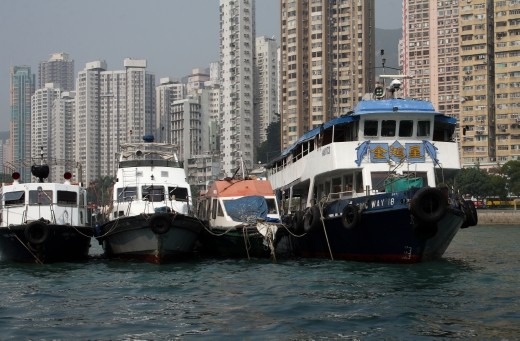 Boats moored up on the waterfront with high rises in the background