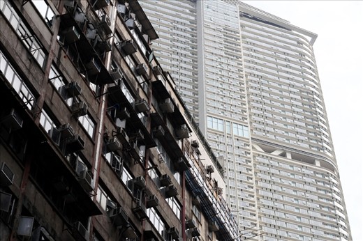 Contrast of public housing against the shiny new backdrop of a highrise.