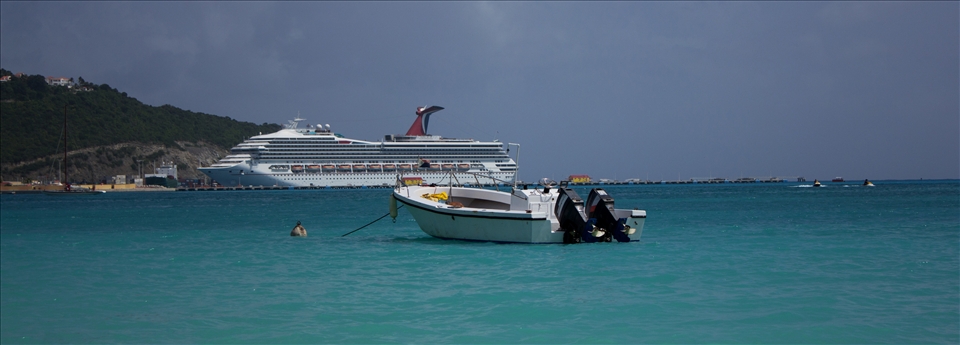 Small fishing boat and in background his enemy Carnival Cruiser...