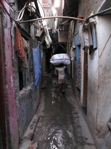 The lack of air and space is a leitmotiv here and the light is barely reaching the ground. It's not uncommon to see children working instead of being at school, like this kid carrying a package bigger than him.