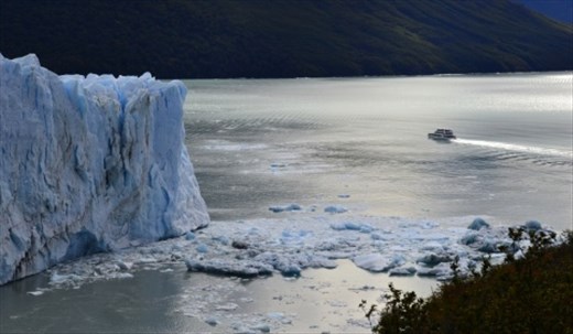 A ferry boat dwarfed by the vast Perito Moreno glacier, El Chalten National Park