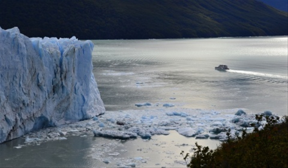 A ferry boat dwarfed by the vast Perito Moreno glacier, El Chalten National Park