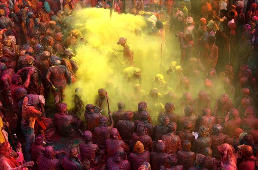 Indians play with colored powder during Lath mar Holi at Nandagao, 32