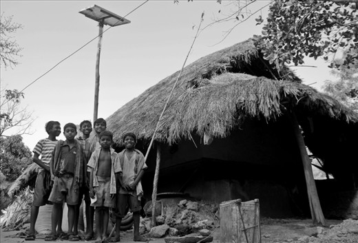 In the quaint hamlet of Huchukpara in Suri (Birbhum,West Bengal),  Sujoy (the boy with the unbuttoned shirt) and his friends proudly pose in front of his Solar powered house. The Solar Panel can be seen at the background on top of an improvised bamboo pole. In this remote village with no electricity, Solar energy is literally lighting up a lot of lives and smiles.