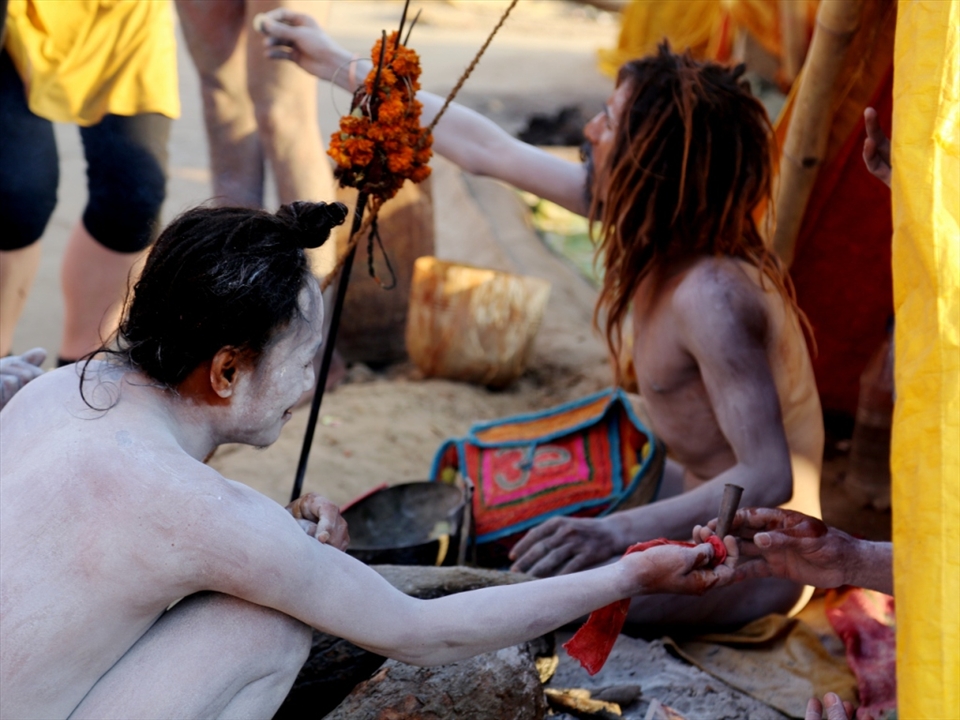  ASCETICS ENJOYING THE DAY.Ascetics spend their day doing penances and worshipping Lord Shiva, the Diety of this place.They live on flesh,liqour,tobacco smoking,ganja,etc.They keep themselves nude and smear their body with Ash throughout the year irrespective of the climate.Once in 12 years they have interaction with public/ outside world.It is interesting that one foreigner lady has given currency to one of the ascetic for whom this wordly possession is meaningless.The other ascetic is giving Cheelum for smoking to another ascetic inside.They enjoy life like this.