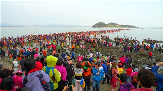 As the tide recedes, thousands of people set out on foot to cross the narrow land bridge to a nearby island. 