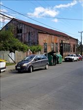 The old buidling was made out of metal, which is why I took this photo; however, note the garbage picker. He just moved to the second can.: by suziqtn, Views[203]