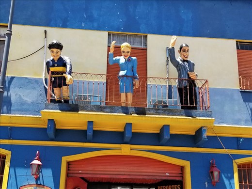 I climbed between 2 buses to get this photo of Juan and Evita Peron with a soccer player on the balcony.