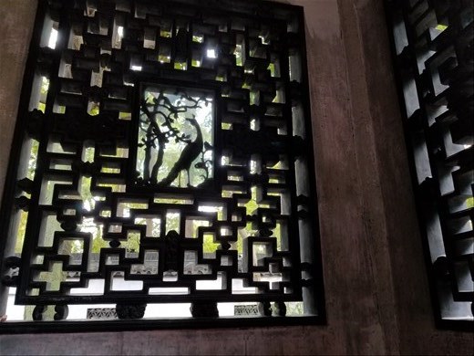 Through a window at the Yu Gardens. No matter what I do, I cannot get this turned in the correct direction, which is why the peacock looks upside down!