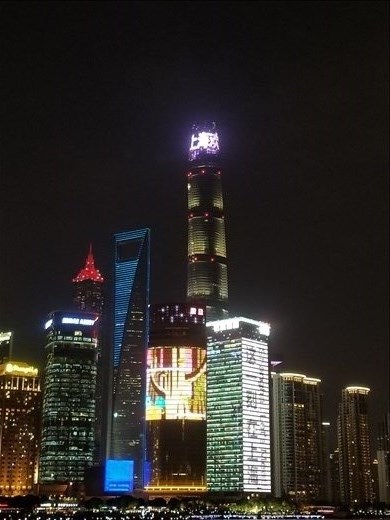 Next to the tallest building, the building lit in blue is called the bottle opener because of the opening near its top to help with wind.