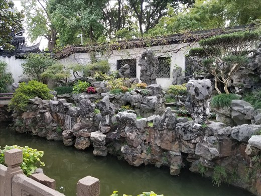 Yin and Yan in the Yu Gardens. Note the dragon on top of the wall in the background.