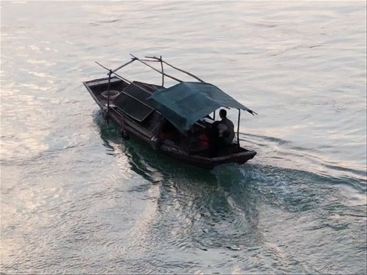 Here a small sampan floats placidly down the river. The one we took was much larger.