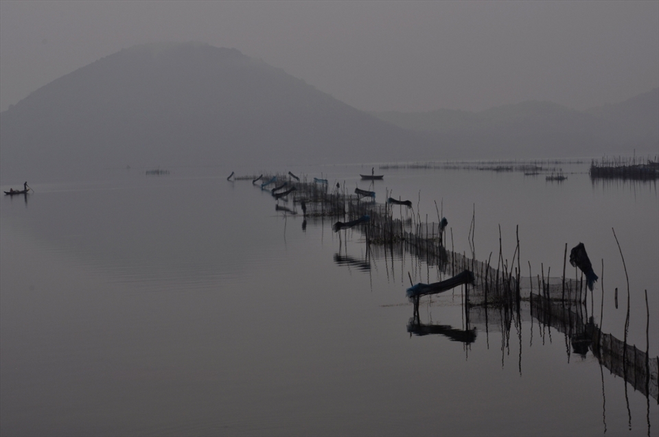 Fishermen spread their net on the lake water to catch fish...