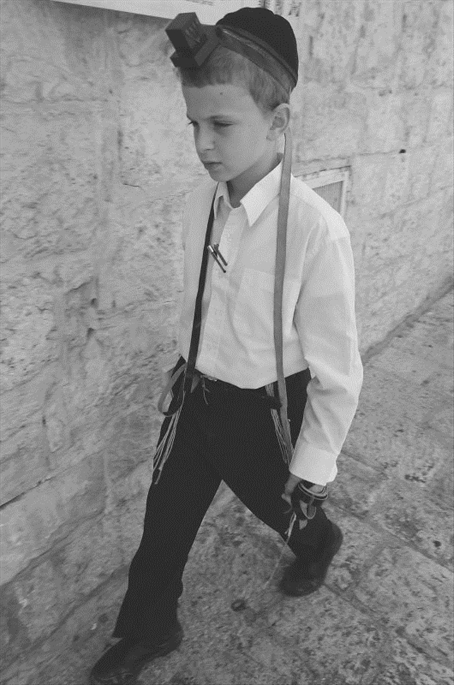 A little boy wearing tefillin and displaying his manhood and dedication. 