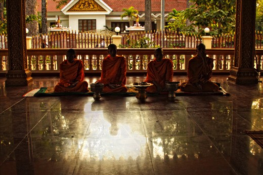 Four monks in meditation at a local temple in Siem Reap