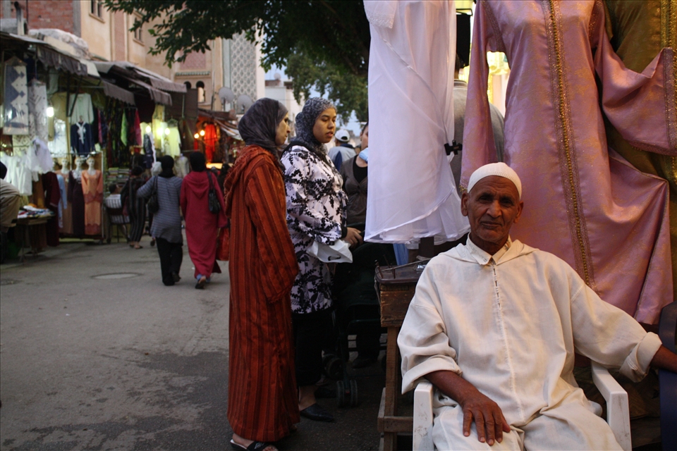 An old man selling textiles.