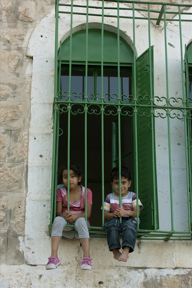 Two children welcomed our group of international visiters to their home in Hebron. Their home had become such a frequent target for Israeli aggression that all of the windows have steel bars to protect the inhabitants, and the children are not allowed to leave their home for more than 10 minutes at a time. Even with these horrendous circumstances for a child to be reared, they still have the curiosity and childishness to wave and smile to new people. 