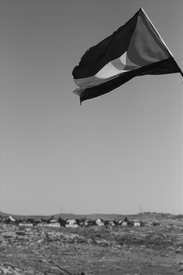 A tattered Palestinian flag flys in the bedouin camp of Sussya. In the background is a large settlement, which seems somewhat ironic, as the water and crops that the settlers live off was the property of the tribe only  5 years ago. Now, their water is contaminated, they have no crops, and they receive regular attacks on their tents and residents.  