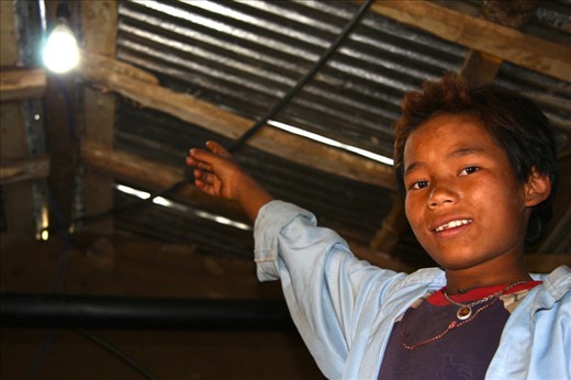A local boy points at the light bulb as the generator powers up. This bulb not only lights up the room, but it also lights up their hearts and minds. “Now I don’t have to go to bed when the sun goes down.”