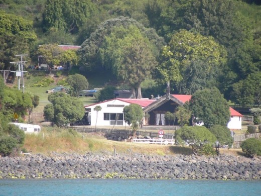 The whare (meeting house) is recognizable by the carved totem above the entrance.